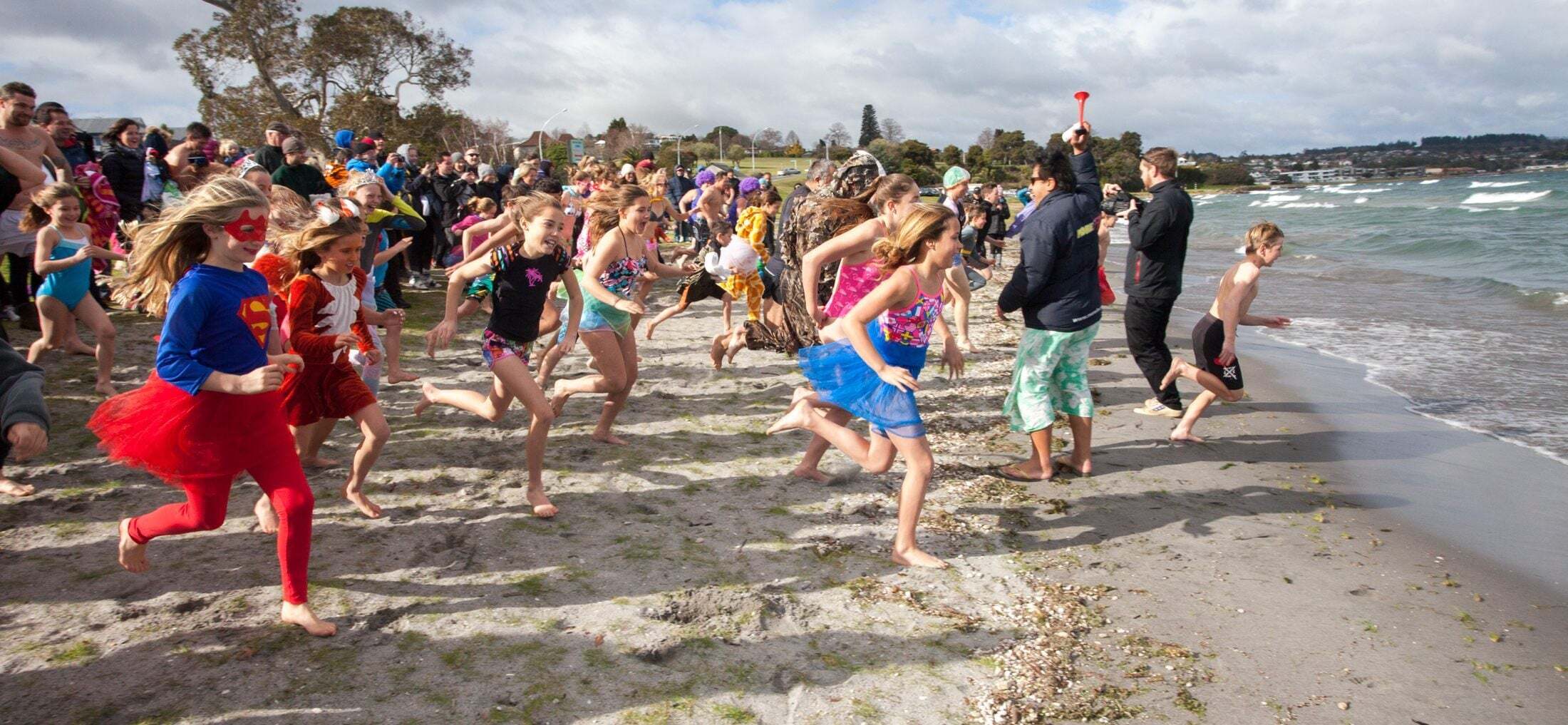 2504_img_taupo_town_lakefront_event_family_friendly_swimming_fun_winter_festival_crowed_running_into_lake